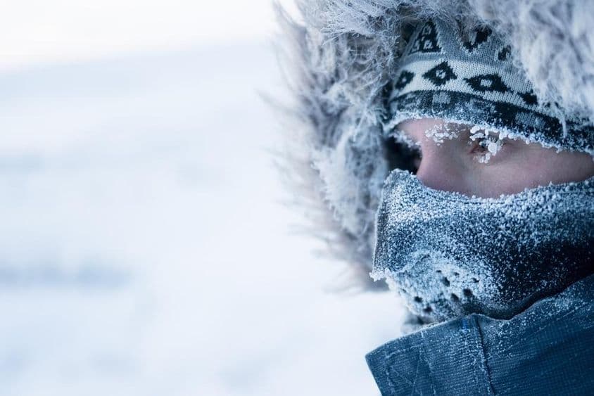 Muž v zimnom oblečení a maske, chladná arktická klíma