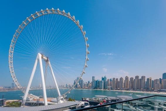 Ruské koleso Ain Dubai s mrakodrapmi a morom v pozadí.