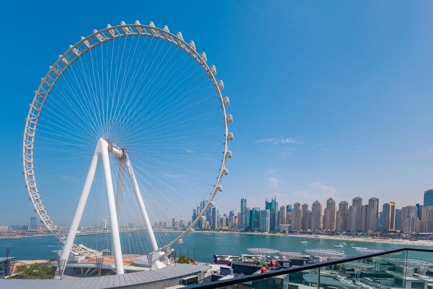 Ruské koleso Ain Dubai s mrakodrapmi a morom v pozadí.