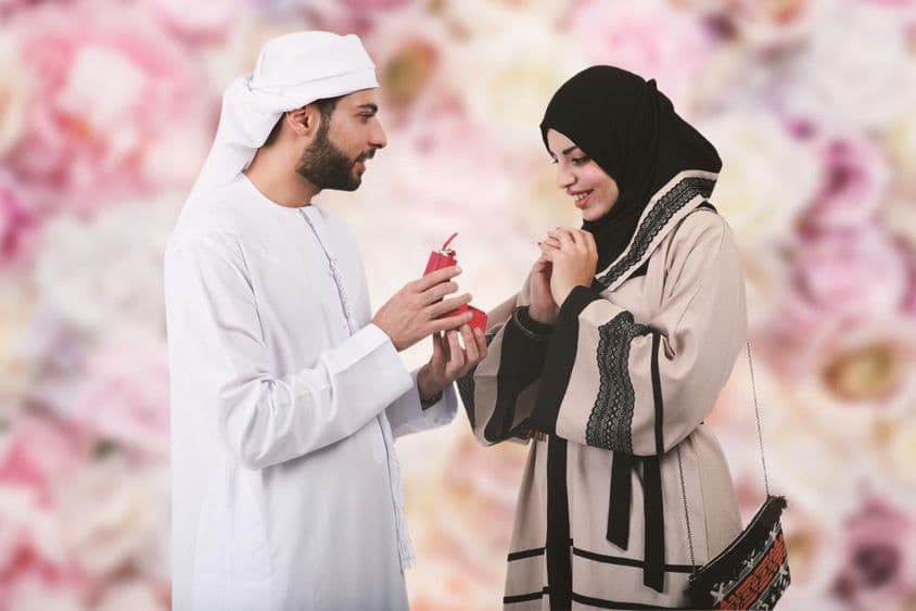 Milý arabský pár, arabský muž žiada o ruku arabskú ženu, ponúkajúc jej zásnubný prsteň.