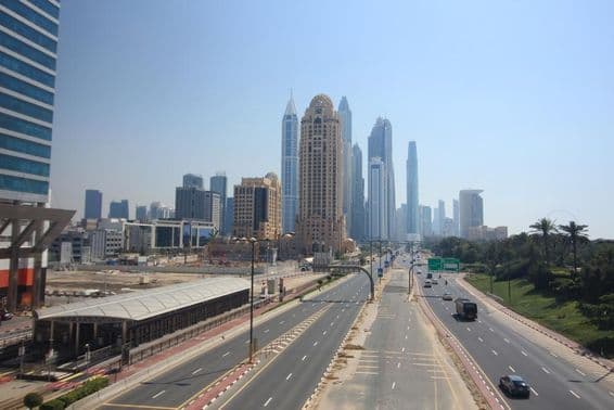 Dubajská ulica s mrakodrapmi a električkou v pozadí.