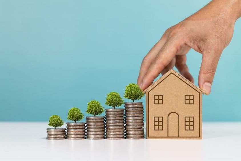 Mince s rastúcim stromom, indikujúce rast investícií do nehnuteľností.