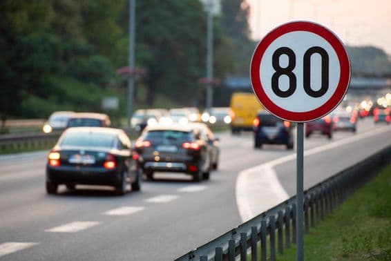 Značka 80 km/h na rušnej ceste.