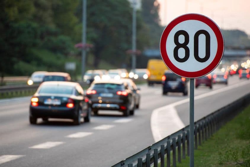 Značka 80 km/h na rušnej ceste.