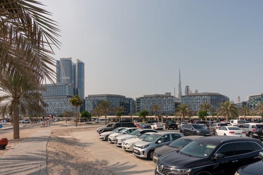 Parkovacia oblasť s výhľadom na moderné kancelárske budovy Dubaja.