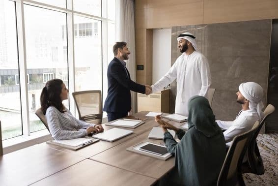 Arabskí a európski obchodníci si podávajú ruky na tímovom stretnutí, korporátna diskusia.