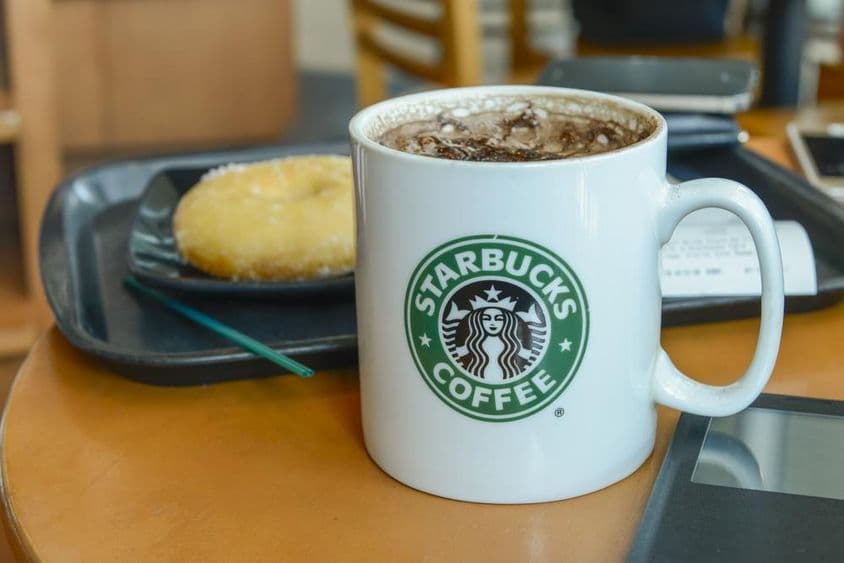 Kakaové cappuccino v horúcom, pariacom sa hrnčeku v kaviarni Starbucks.