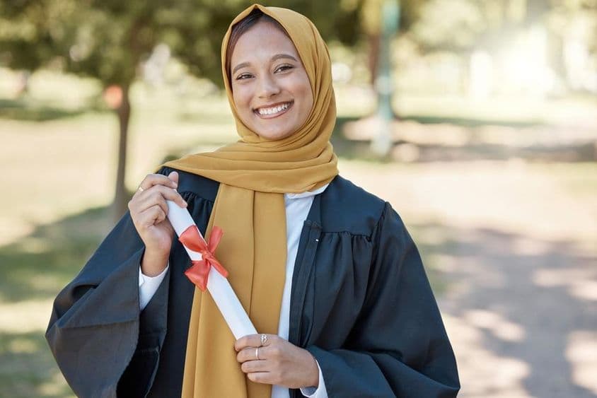 Islamský študent s diplomom na univerzite vonku.