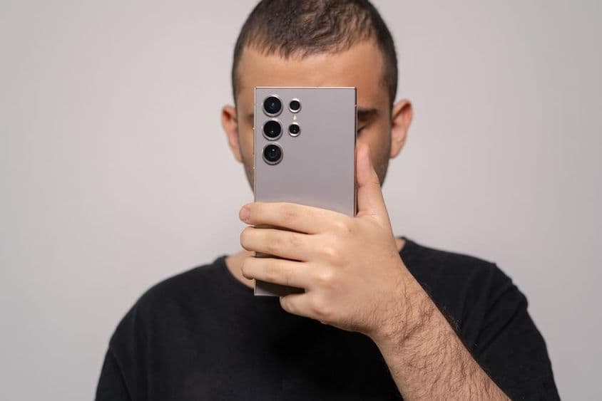 Muž držiaci Samsung S24 Ultra smartfón, zdôrazňujúci elegantný dizajn.