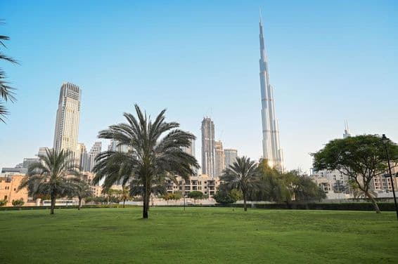Dubaj, Spojené arabské emiráty, zelený park v obytnej oblasti s Burj Khalifou v pozadí.