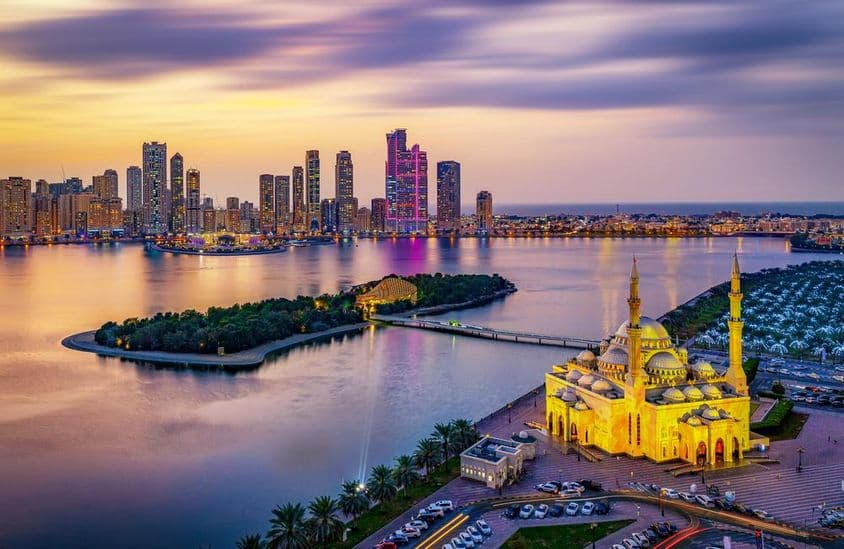 Panoráma mesta Sharjah pri západe slnka.