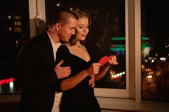 Zamilovaný pár na rande na Valentína, stojaci pri okne.