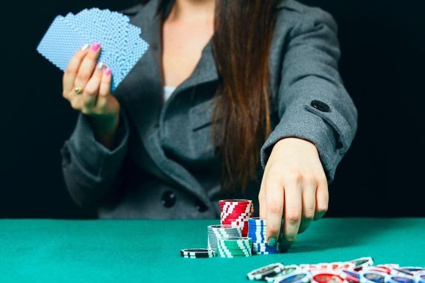 Blackjack v kasíne, žena stavia stávku s čipmi.