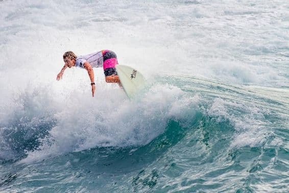 Mladík surfuje na veľkej vlne.
