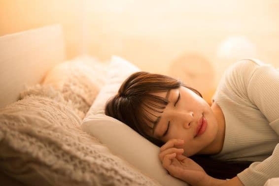 Žena spí v posteli.