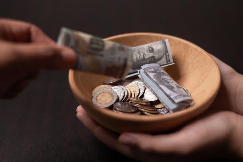 Príspevok zbieraný v drevenej nádobe.