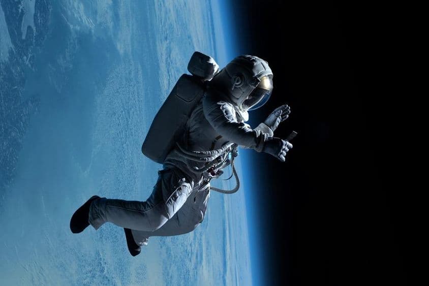 Žena astronautka počas telefonovania z vesmírnej stanice ďaleko vo vesmíre.