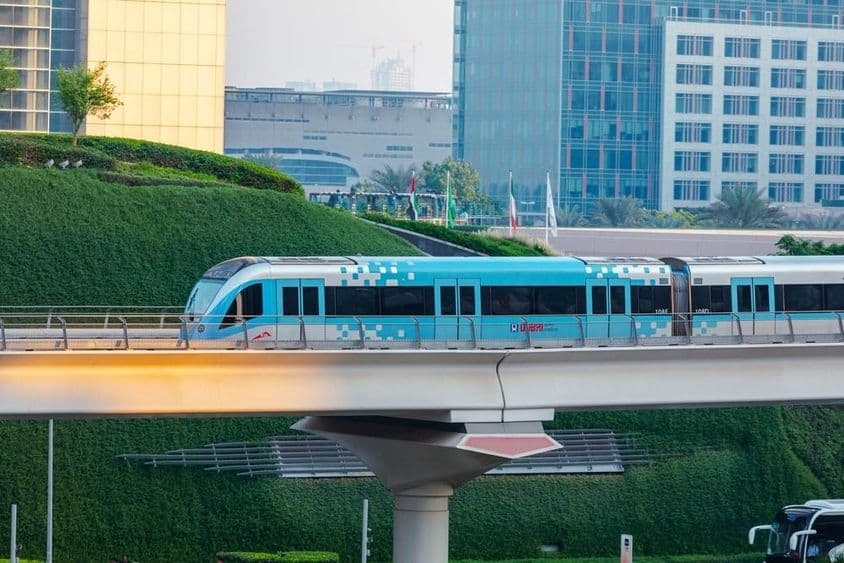 Bezdrôtový vlak metra sa pohybuje v meste Dubaj počas slnečného dňa.