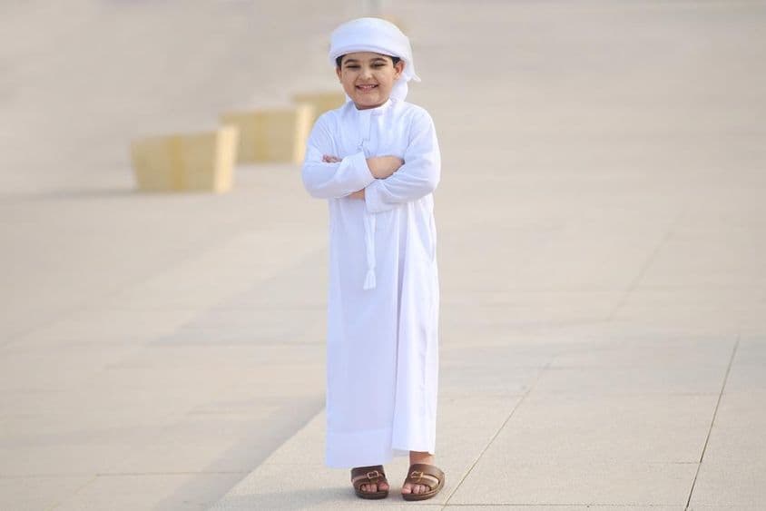 Mladý arabský študent usmievajúci sa na ceste do školy.