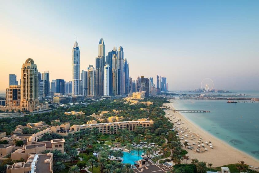 Panoráma mesta Dubaj Marina a slávne pláže Jumeirah pri východe slnka.