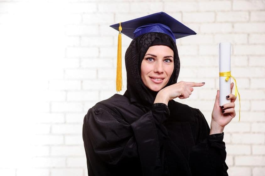 Šťastný Moslimský absolvent s diplomom v interiéri.