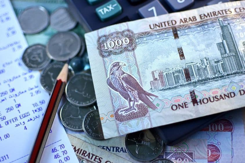 1000 dirhamová bankovka SAE a hrsť mincí.