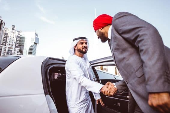 Arabský-indický podnikateľ diskutujúci o budúcich plánoch v Dubaji v limuzíne.