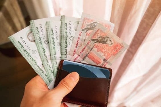 Dirham bankovky držiace s peňaženkou.
