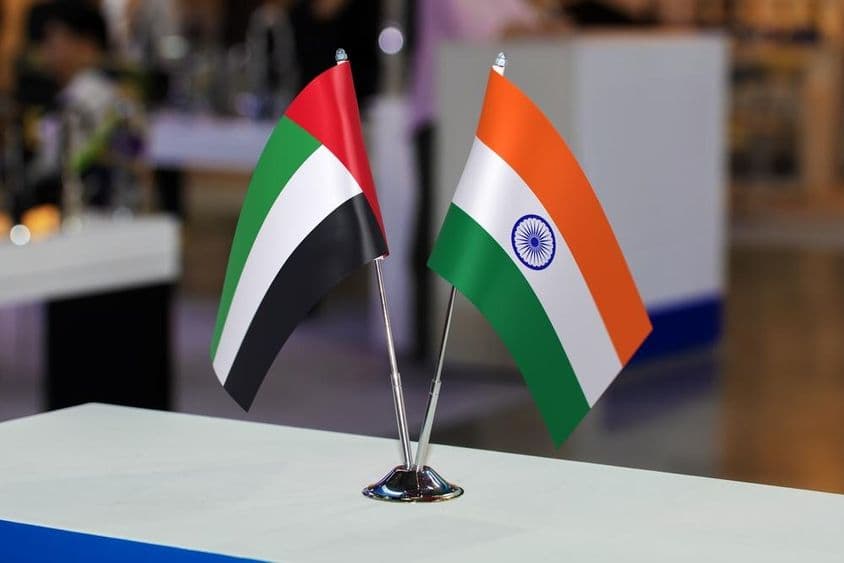 Dve malé stolové vlajky Spojených arabských emirátov a Indie spolu na podujatí.