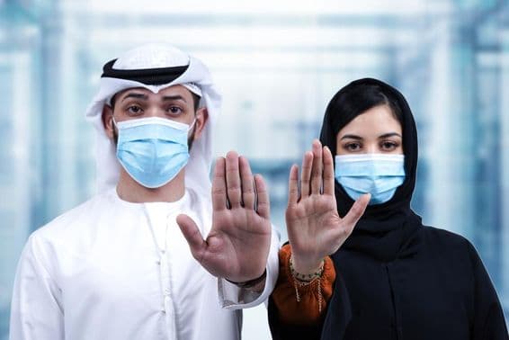 Arab muž a žena nosiaci lekárske masky ukazujúci gesto stop