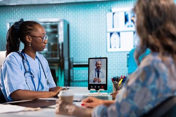 Zdravotná sestra pri videorozhovore s lekárom pre diaľkovú konzultáciu a telemedicínu.