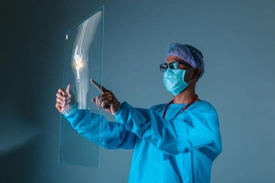 Lekár držiaci pacientovu rádiografiu kosti pred operáciou.