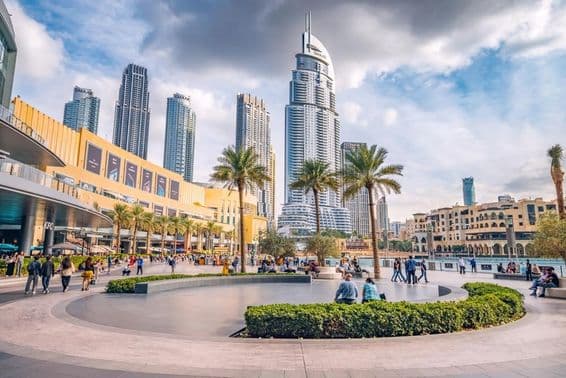 Davy turistov kráčajú na námestí a promenáde pri vchode do Dubai Mall.