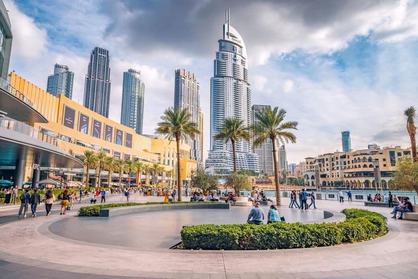 Davy turistov kráčajú na námestí a promenáde pri vchode do Dubai Mall.