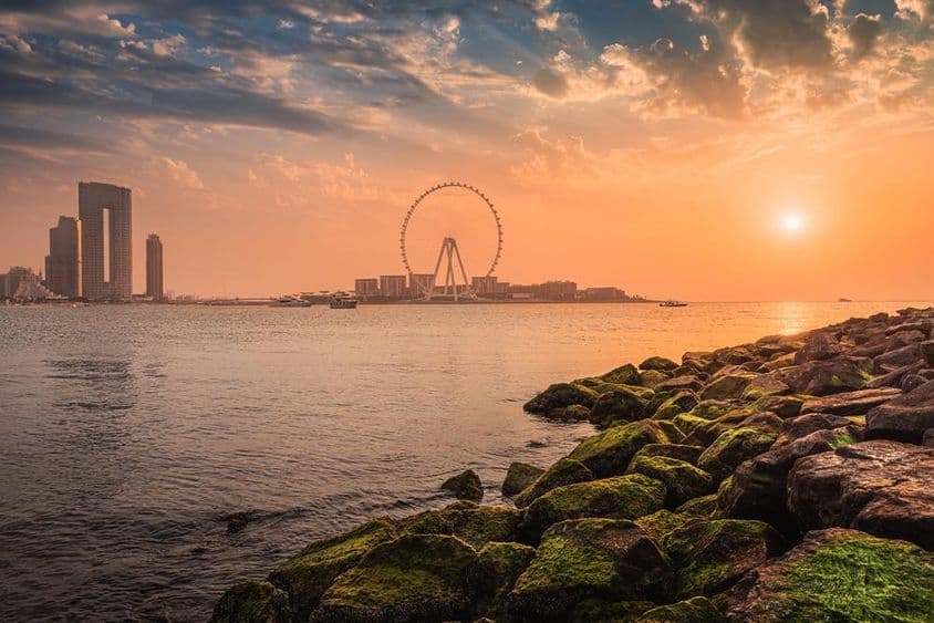 Západ slnka nad ostrovom Blue Waters s slávnym dračím okom Ferrisovho kolesa v Dubaji.