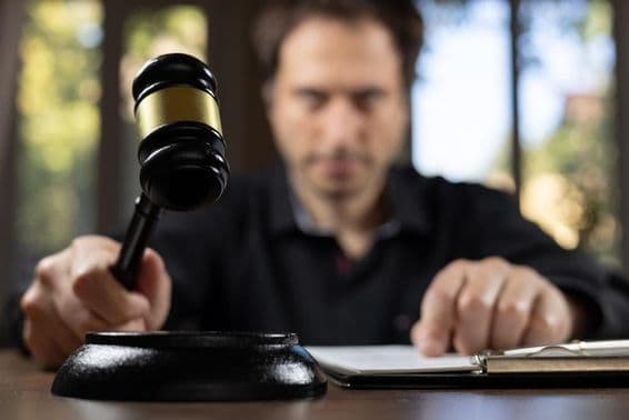 Sudca držiaci kladivo signalizuje koniec procesu.