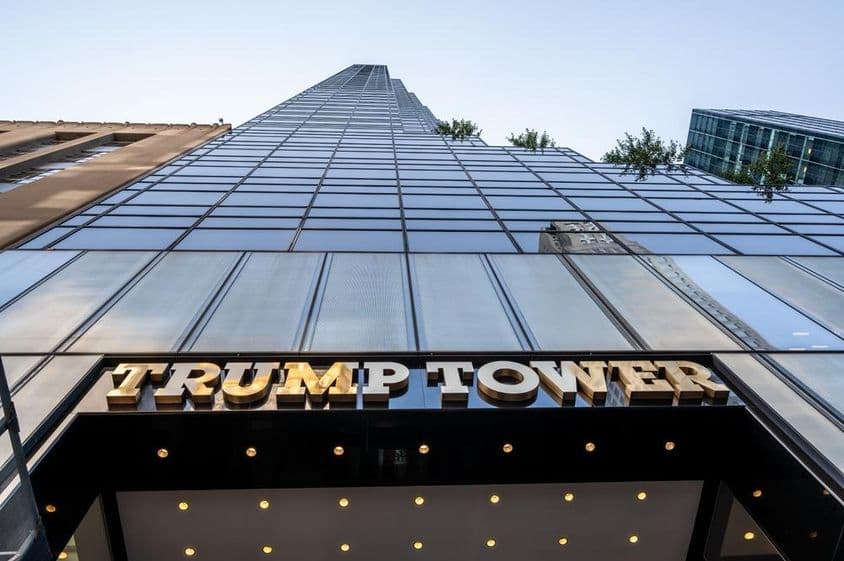 Ikonická fotografia vstupu Trump Tower so zlatým kovovým nápisom.