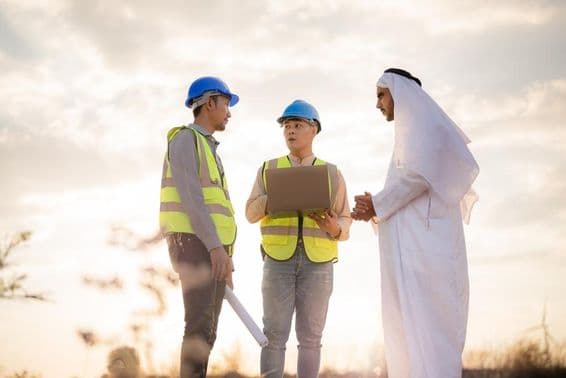 Ázijský inžinier a arabský podnikateľ diskutujúci na stavbe.