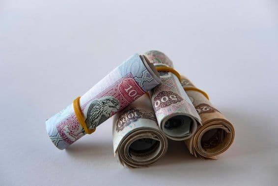 Kolekcia dirhamovej meny a mincí SAE zvinutých a naskladaných.