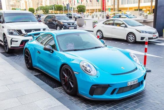 Dubaj, modrý Porsche na parkovisku.