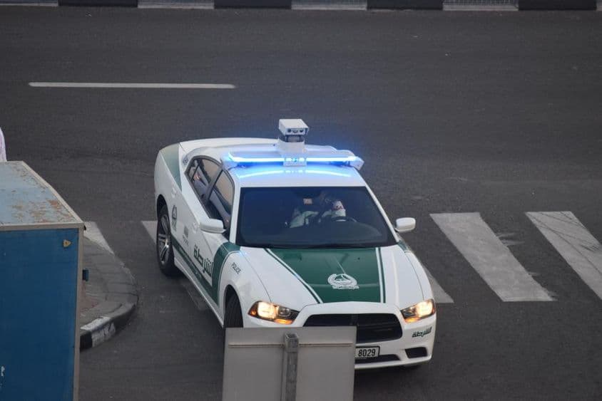 Policejné auto v Dubaji jazdí po ulici.