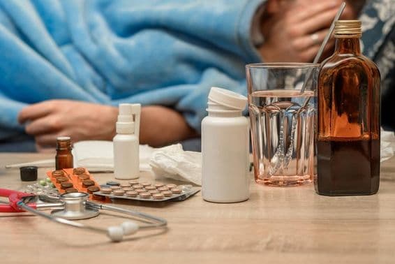 Muž s nádchou a horúčkou leží v posteli.