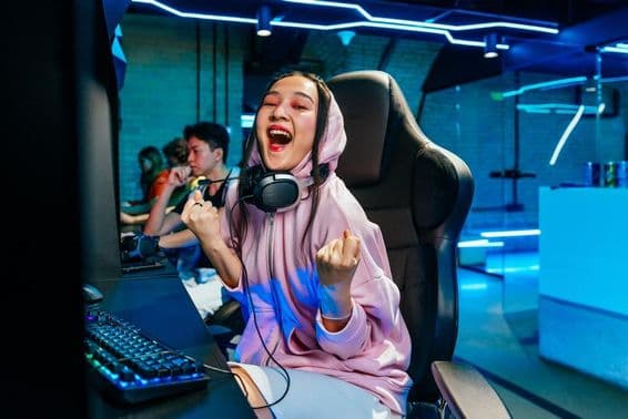 Krásna mladá Ázijka hrajúca videohry v internetovej kaviarni.