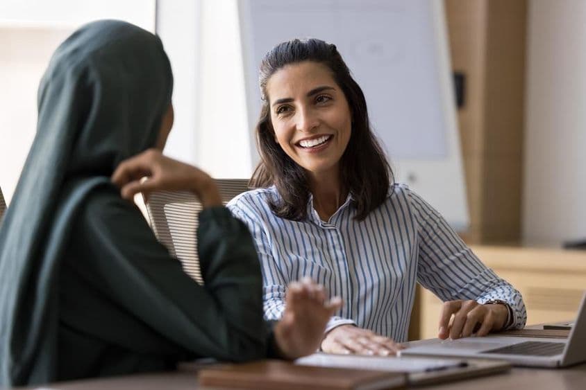 Španielsky hovoriaca podnikateľka konverzuje s arabskou kolegyňou.