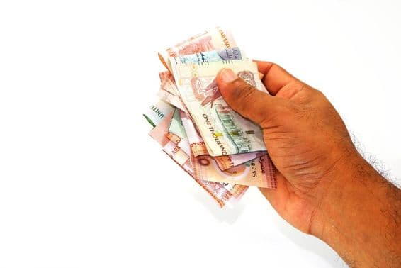 Dirham bankovky držiace v ruke.