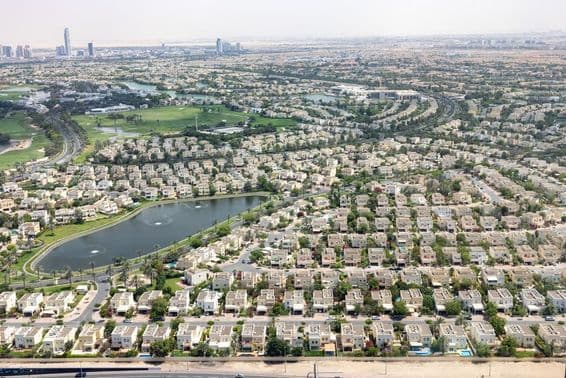Emirates Hills Dubaj s komunitnými domami, jazerom a zeleňou.