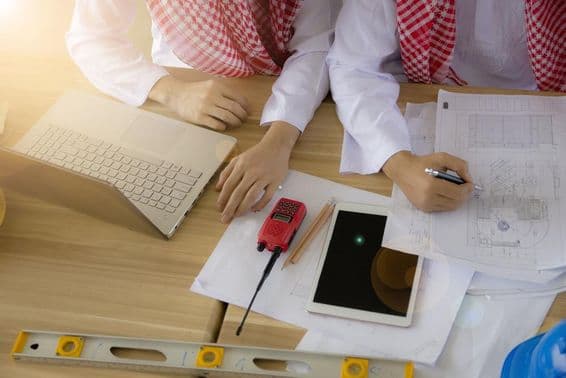 Arabský inžinier pracujúci za stolom.