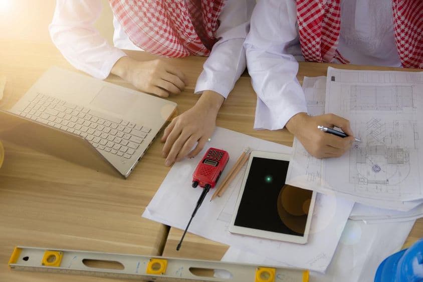 Arabský inžinier pracujúci za stolom.