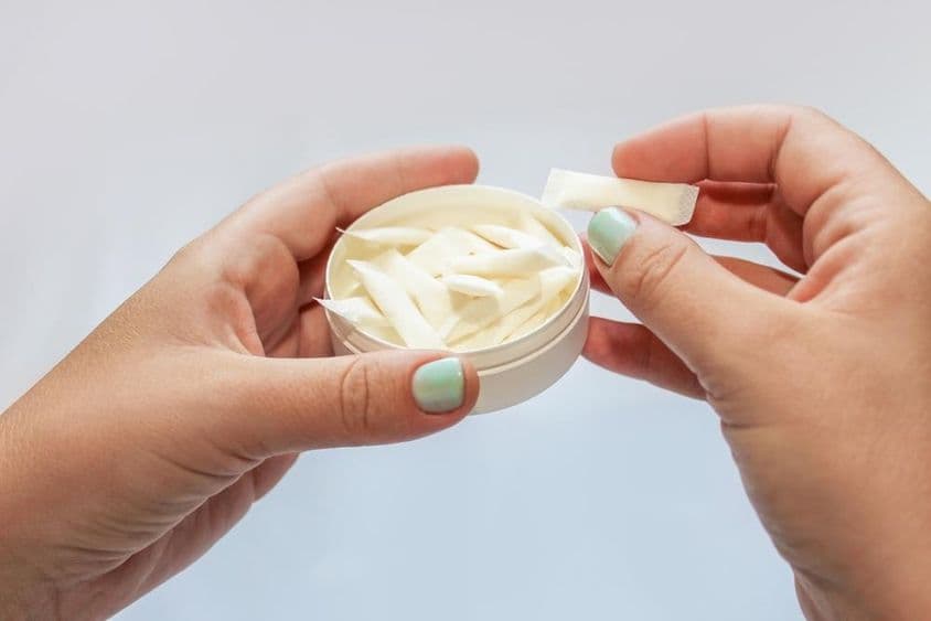 Snusové vrecká, nikotínové náplasti v rukách.