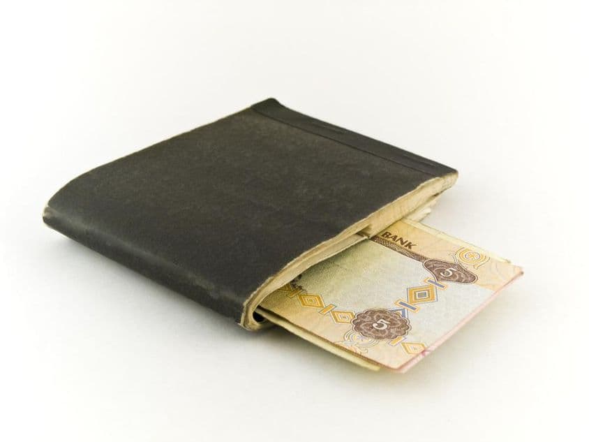 Starý šekový zošit a bankovka v hodnote päť dirhamov.